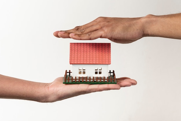 Real estate agent and client holding a toy house