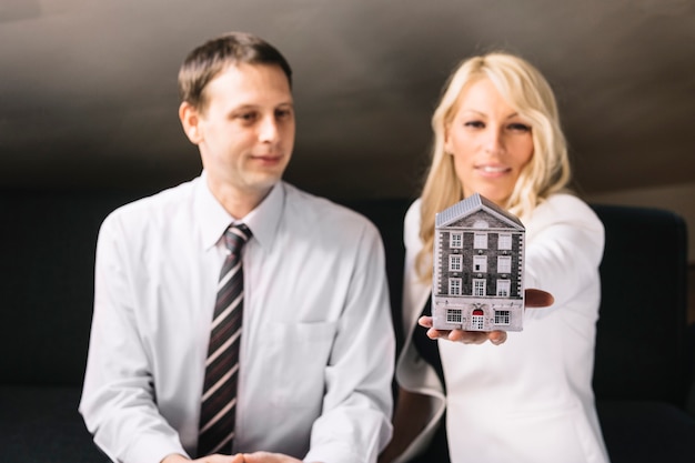 Real estate agent holding toy house