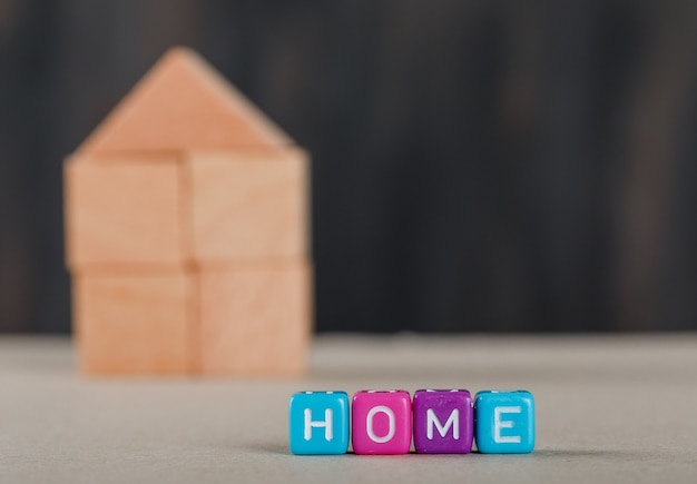 Real estate concept with colored cubes, wooden home and white.