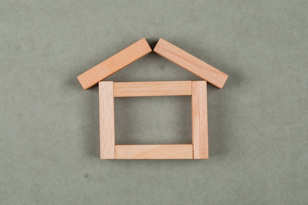 Real estate concept with wooden blocks on grey background flat lay.