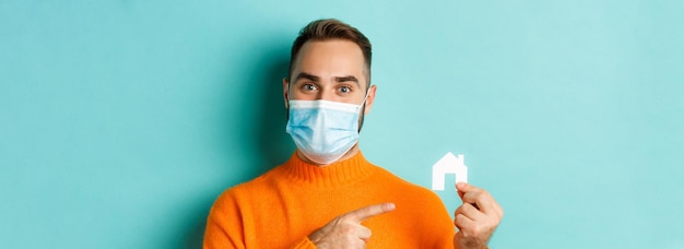 의료용 마스크를 쓴 성인 남성의 부동산 및 코로나바이러스 대유행 개념 근접 촬영