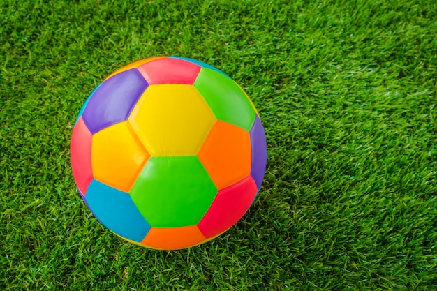 緑の芝生の上で本物の革カラフルなマルチカラーのサッカーボール。