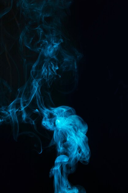 Realistic blue smoke spread on black background