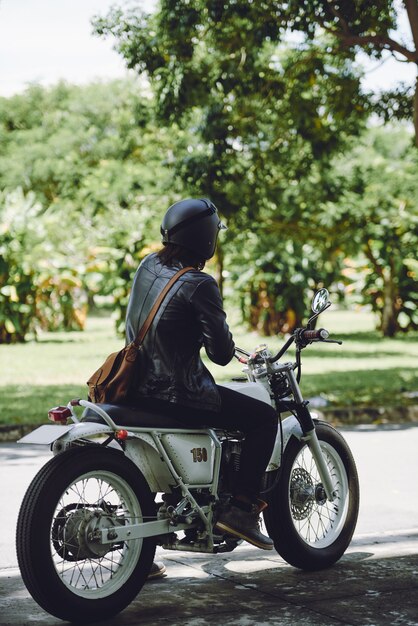 Rear side view of unrecognizable man riding bike on a sunny day