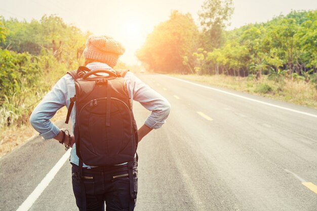 Rear view of adventurer walking at sunset