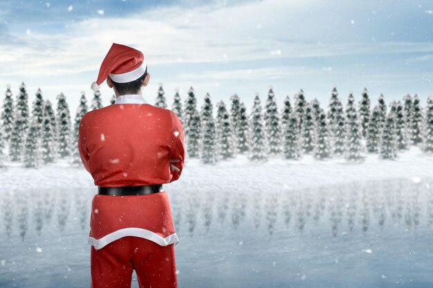 Rear view of an asian man in santa costume standing on the snowfield with snowfall background. merry christmas