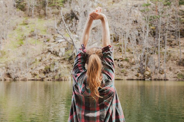 Rear view of blonde girl stretching her arms