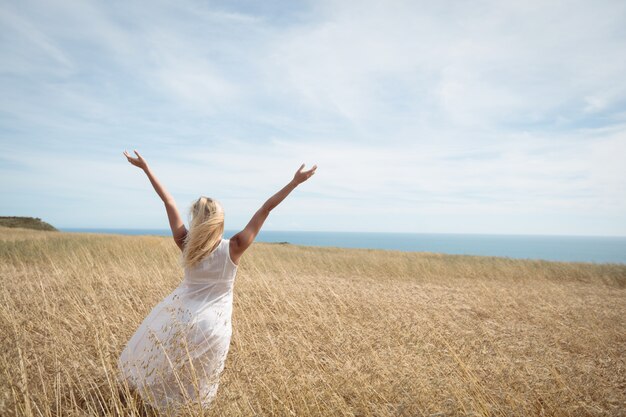 Rear view of blonde woman standing in field