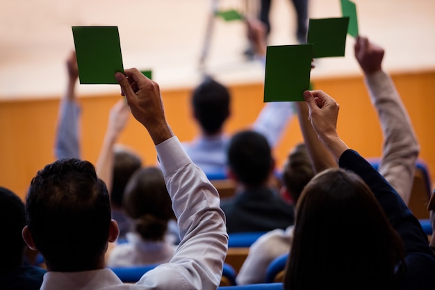 Free photo rear view of business executives show their approval by raising hands