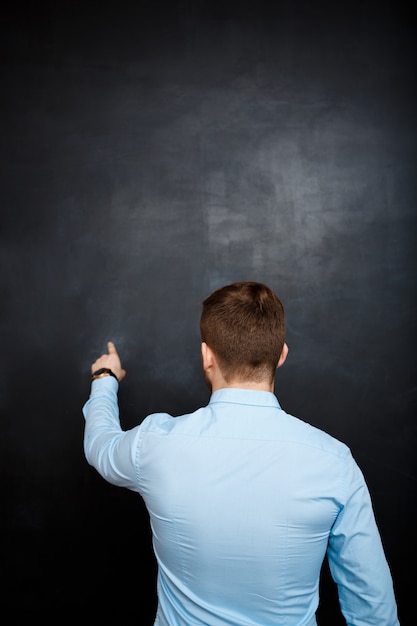 Rear view of business man over blackboard copyspace