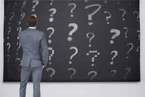 Free photo rear view of businessman looking at question marks