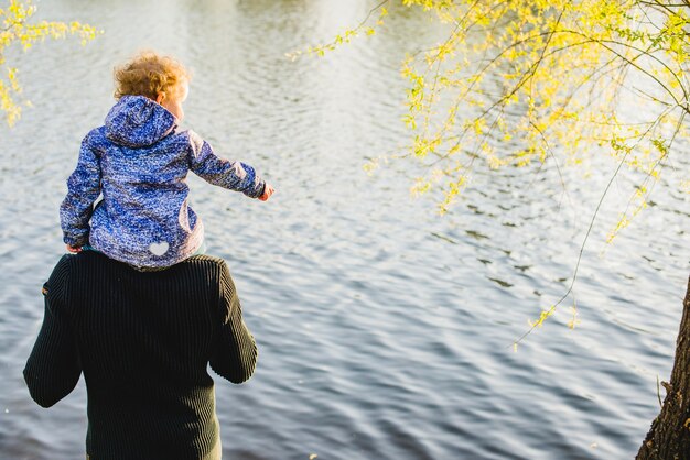 父親の肩にある子供の後ろ姿