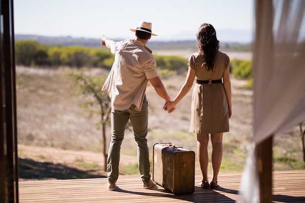 Rear view of couple pointing at view on a sunny day