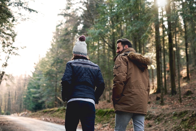 Free photo rear view of father and son walking in autumn forest