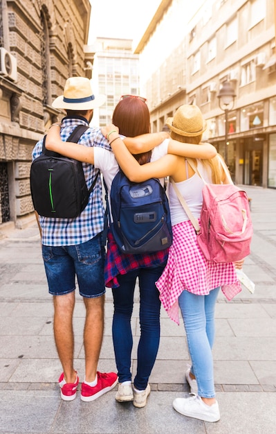 Free photo rear view of friends standing on street