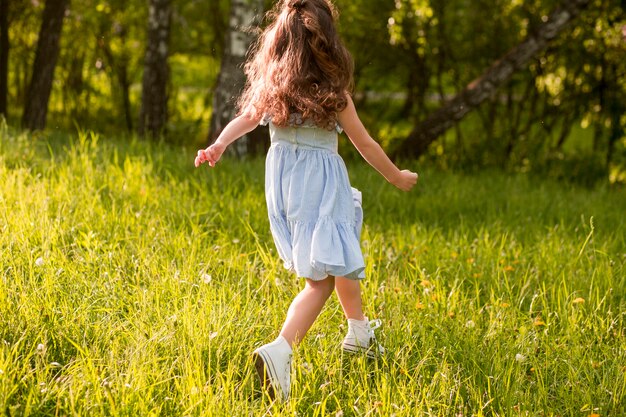 公園で走っている女の子のリアビュー