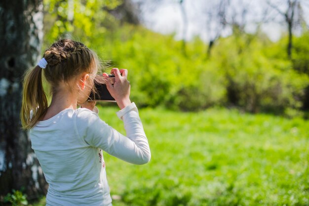 写真を撮っている少女のリアビュー