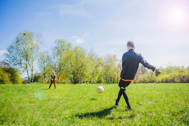 Rear view of goalkeeper hitting the ball