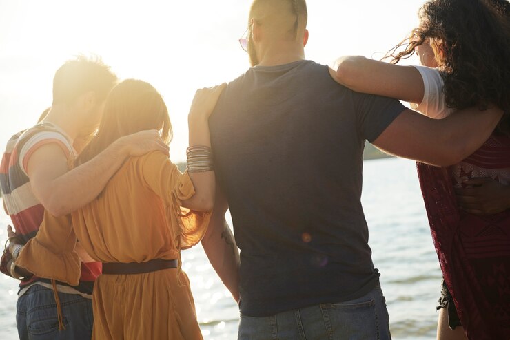 Free Photo rear view of group of friends looking at the sunset