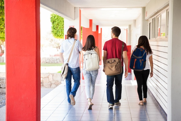 Rear view of a group of university students walking away on a school hallway