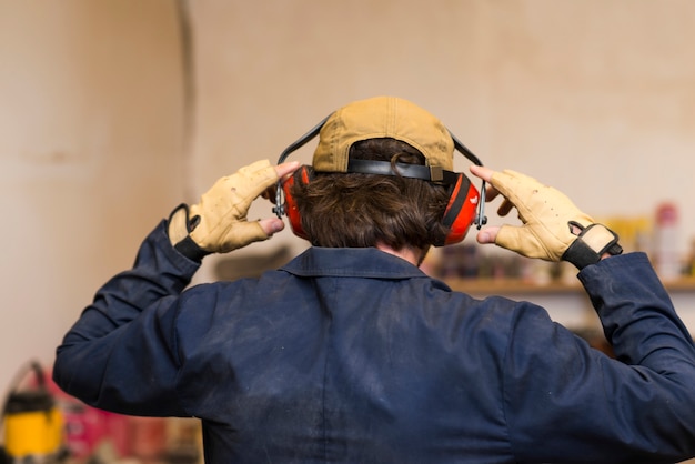 Rear view of a handyman wearing ear defender over his ear