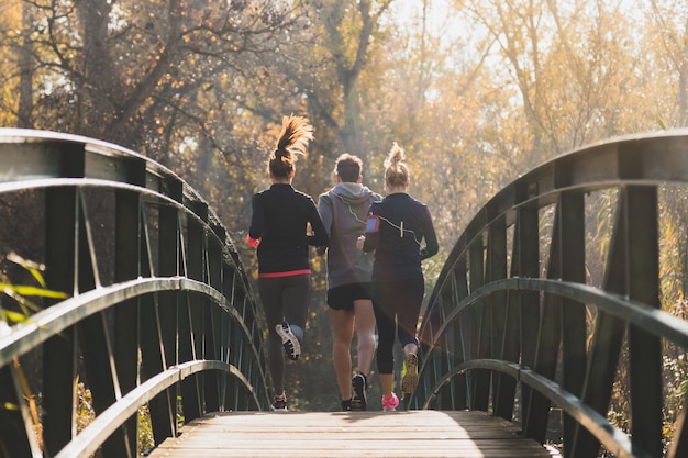 Foto gratuita vista posteriore di persone sane che attraversano il ponte