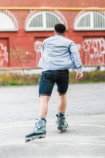 Rear view of a man rollerskating outdoors