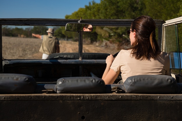 Free photo rear view of man seen through windshield with woman driving vehicle