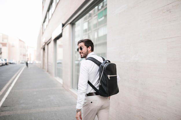 Rear view of a man walking on pavement