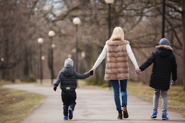 Rear view of mother and children walking