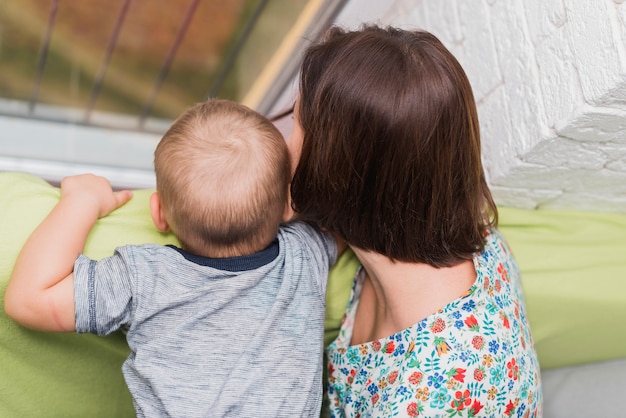 Free photo rear view of mother and son looking at something