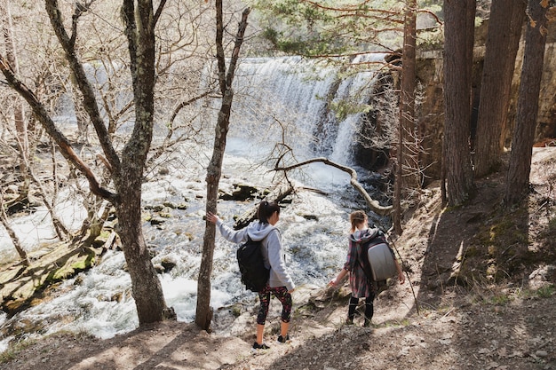 Бесплатное фото Вид сзади девушек, спускающихся к реке