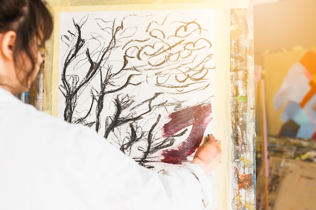 Бесплатное фото Вид сзади женщины, живопись на холсте в мастерской
