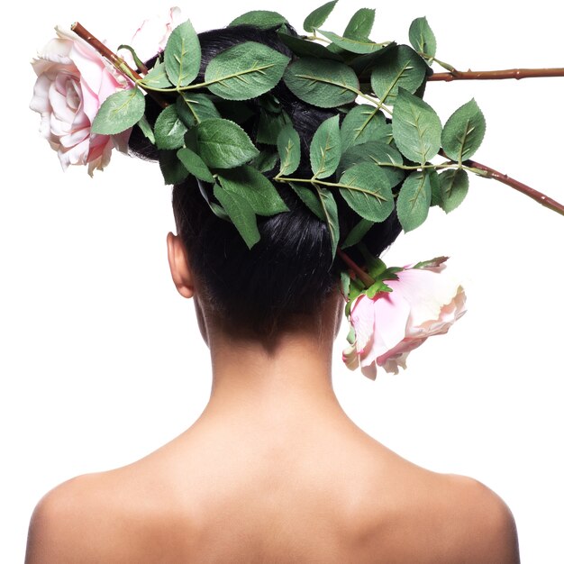 Rear view portrait of the woman with pink flowers in hair - isolated on white