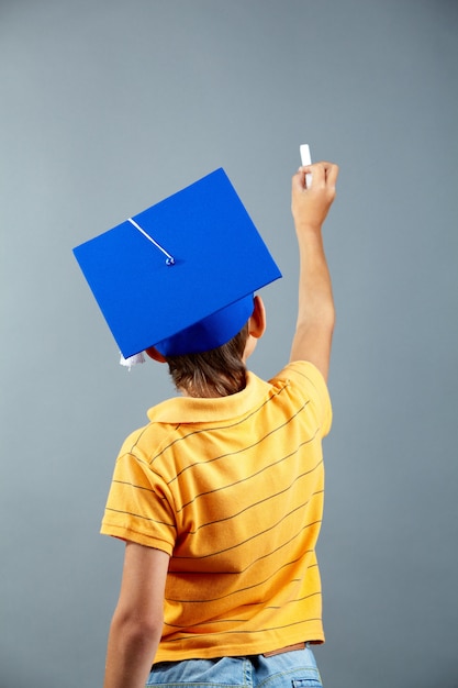 Rear view of schoolboy writing