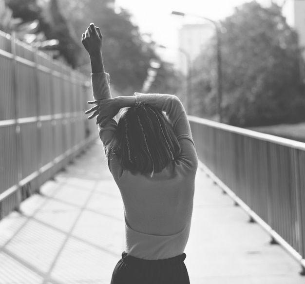 Rear view of skinny girl stretching on the street