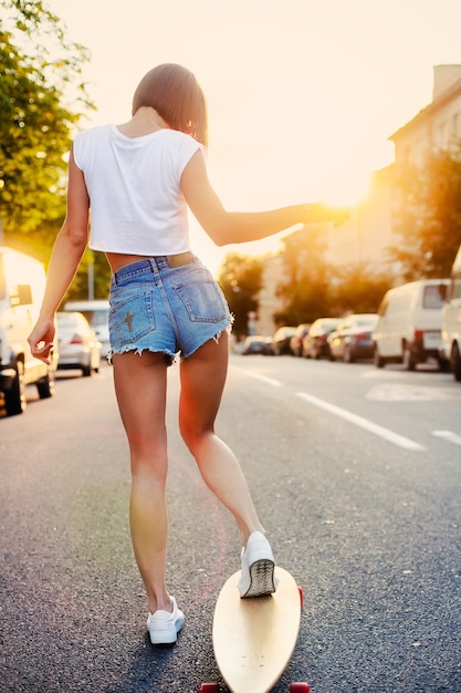 Free photo rear view of teen training with skateboard