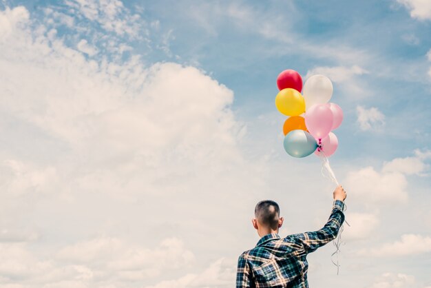 Rear view of a teenager holding balloons