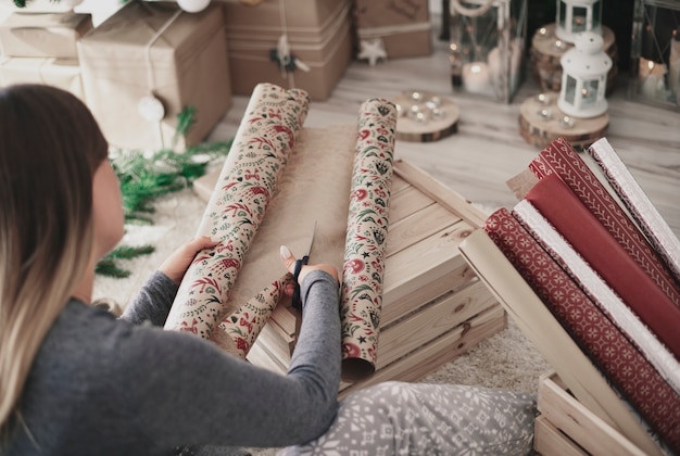 Rear view of woman cutting a christmas paper