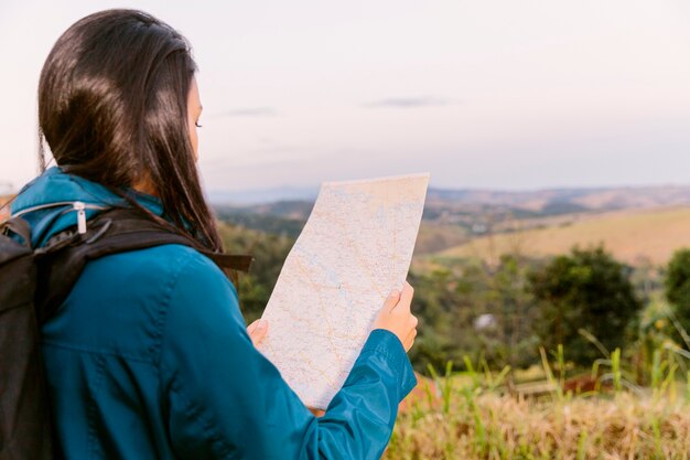 Free photo rear view of a woman looking in map