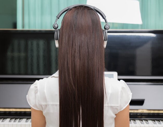 Rear view of woman playing piano