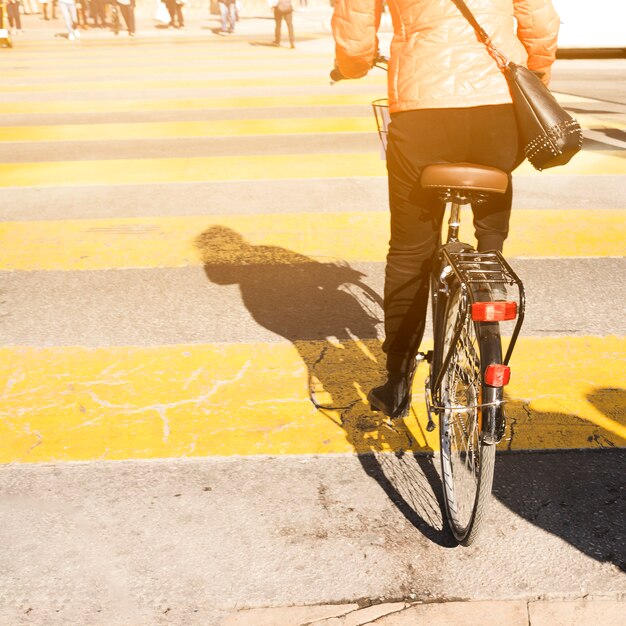 Rear view of a woman riding the bicycle on street