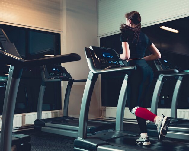 Rear view of a woman running on treadmill