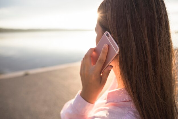 携帯電話で話す女性のリアビュー