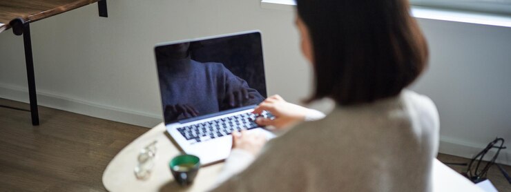 無料Photo ラップトップ コンピューターの画面を入力して作業する女性の背面図は、コピー スペースの女性のために空です