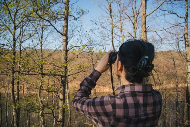 Rear view of woman using binoculars