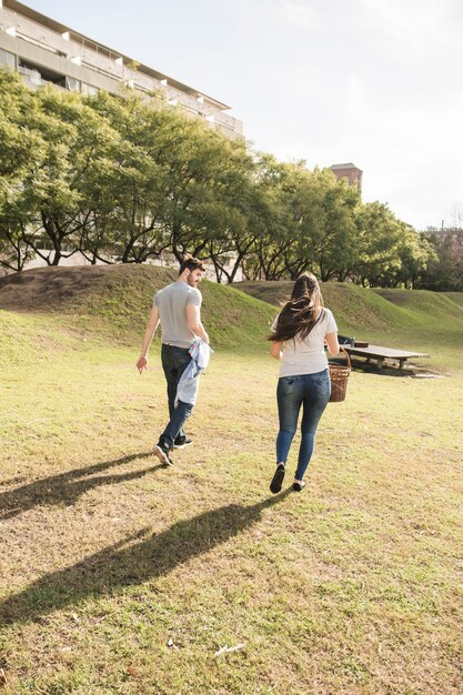 公園で歩く若いカップルのリアビュー