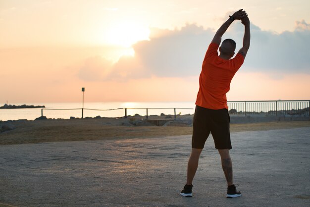 Rear view of young man doing side bend exercises