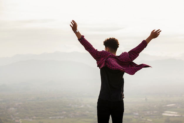 Rear view of young man with raised hand