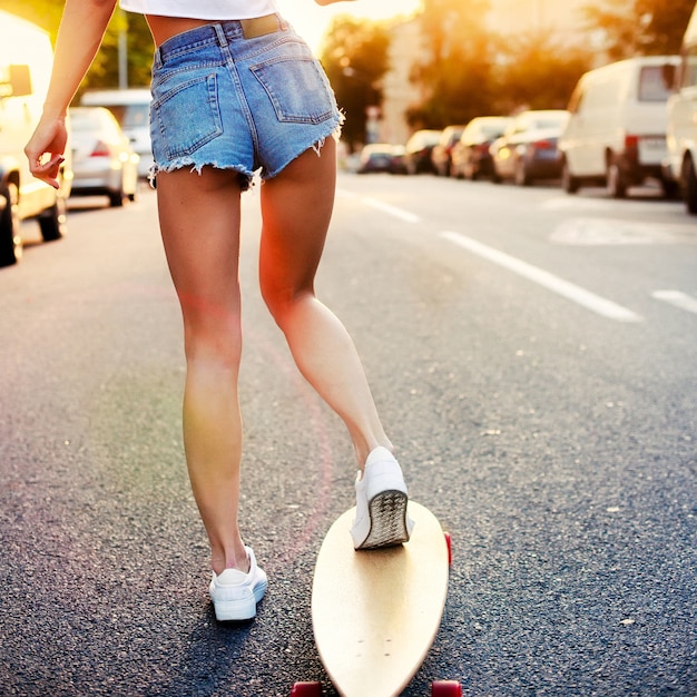 ショートパンツやスケートボードで若い女性の背面図